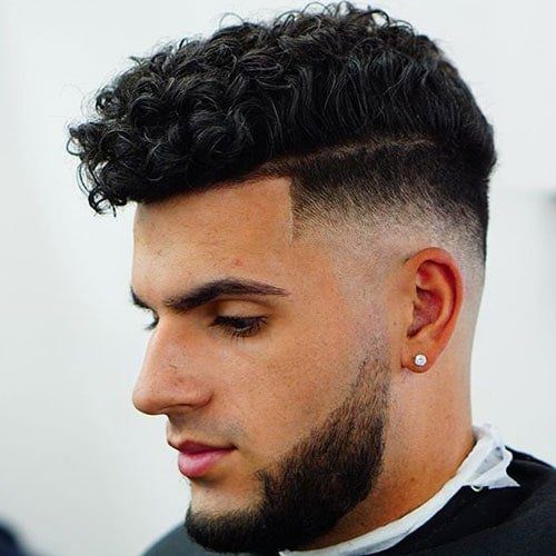 Thick curly haircut with top skin fade and full beard